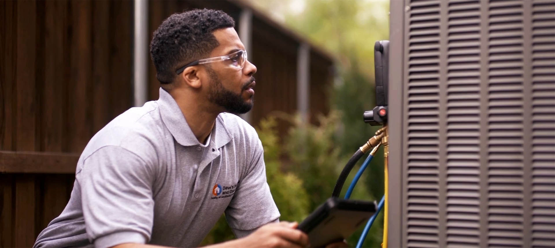 Technician working on air conditioner outside