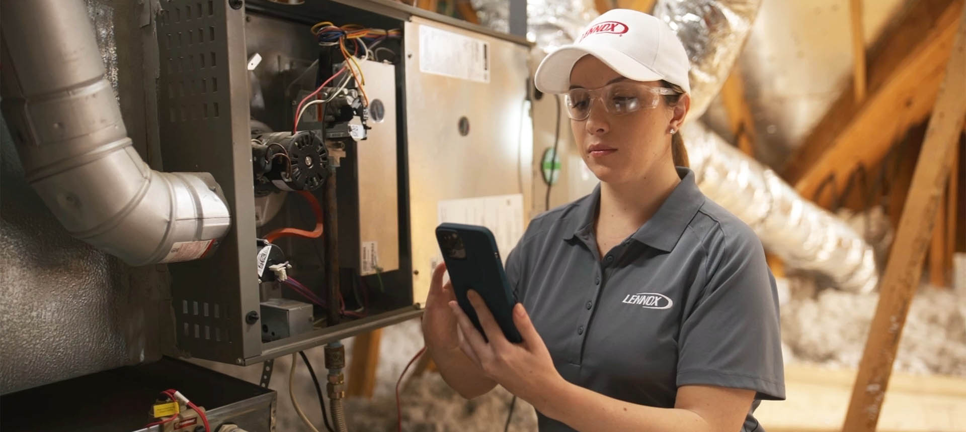 Technician wearing baseball hat performing furnace maintenance